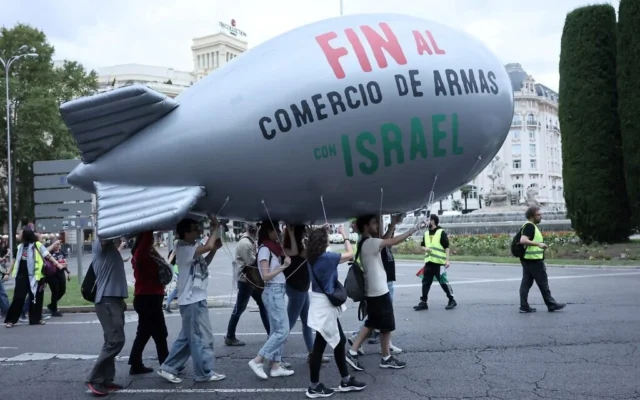 Des manifestants défilent avec un ballon revêtus de l'inscription « Cessez le commerce des armes avec Israël » lors d'un rassemblement anti-Israël en solidarité avec les peuples palestinien et libanais à l'occasion du premier anniversaire de la guerre entre Israël et le Hamas, dans le centre de Madrid, le 5 octobre 2024 (Thomas COEX / AFP)