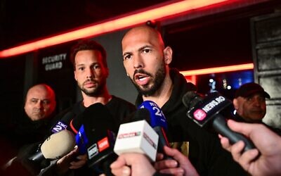 Andrew Tate (à droite) et son frère Tristan (2e à droite) s'adressant aux médias à leur arrivée en Roumanie après leur retour des États-Unis, à Bucarest, le 22 mars 2025. (Crédit : Daniel Mihailescu/AFP)