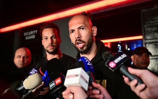 Andrew Tate (à droite) et son frère Tristan (2e à droite) s'adressant aux médias à leur arrivée en Roumanie après leur retour des États-Unis, à Bucarest, le 22 mars 2025. (Crédit : Daniel Mihailescu/AFP)