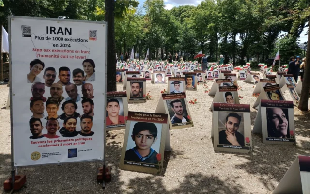 Des portraits d'Iraniens assassinés exposés sur l'esplanade des Invalides à Paris, le 8 juillet 2025, dans le cadre d'une campagne menée par des organisations de défense des droits humains visant à mettre fin aux exécutions en Iran. (Crédit : Delphine TOUITOU / AFP)