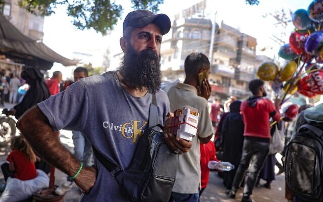 Illustration : Un vendeur de cigarettes gazaoui, sur un marché à Deir el-Balah, dans le centre de la bande de Gaza, plus d'une semaine après la conclusion d'un accord de cessez-le-feu entre Israël et le Hamas, le 18 octobre 2025. (Crédit : Bashar Taleb/AFP)