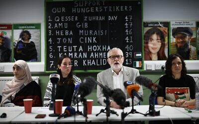 Jeremy Corbyn, au centre, avec d'autres partisans de prisonniers détenus pour des accusations liées au groupe interdit Palestine Action, à Londres, le 18 décembre 2025. Les noms et les photos des grévistes de la faim sont visibles à l'arrière-plan. (Crédit : Henry Nicholls/AFP) Jeremy Corbyn, au centre, avec d'autres partisans de prisonniers détenus pour des accusations liées au groupe interdit Palestine Action, à Londres, le 18 décembre 2025. Les noms et les photos des grévistes de la faim sont visibles à l'arrière-plan. (Crédit : Henry Nicholls/AFP)