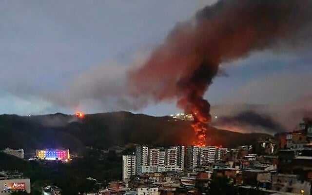 Incendie à Fuerte Tiuna, le plus grand complexe militaire du Venezuela, vu de loin après une série de frappes américaines à Caracas le 3 janvier 2026. (Crédit : AFP)
