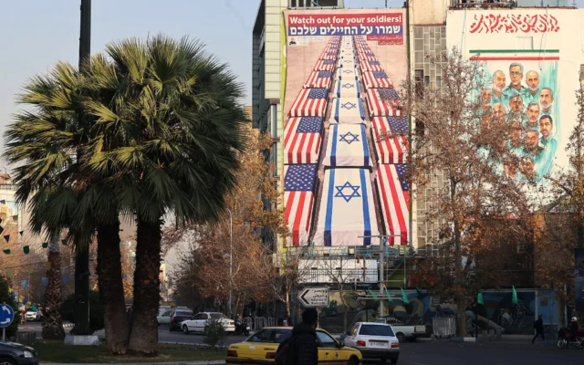 Des Iraniens passent en voiture devant un panneau d'affichage anti-américain et anti-israélien affichant un message qui dit « Prenez soin de vos soldats », à Téhéran le 4 janvier 2026 (Crédit : ATTA KENARE / AFP) Des Iraniens passent en voiture devant un panneau d'affichage anti-américain et anti-israélien affichant un message qui dit « Prenez soin de vos soldats », à Téhéran le 4 janvier 2026 (Crédit : ATTA KENARE / AFP)