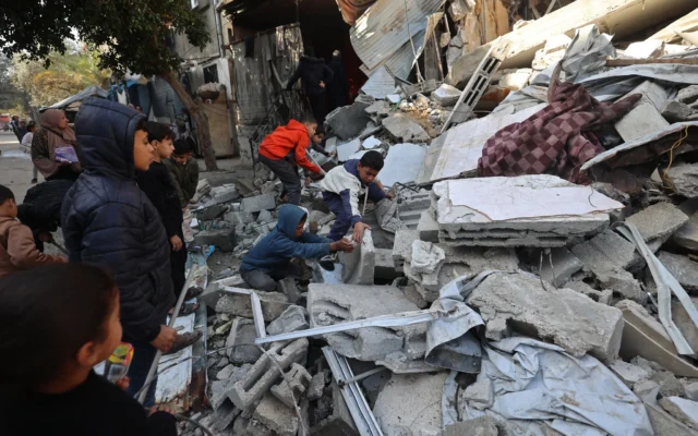Des Palestiniens recherchent leurs effets personnels parmi les décombres d'une maison effondrée, précédemment endommagée, dans le camp de réfugiés de Maghazi, au centre de la bande de Gaza, le 5 janvier 2026. (Crédit: Eyad Baba/AFP)