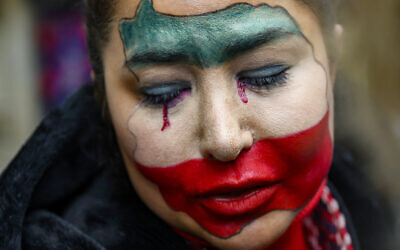 Une manifestante anti-régime iranien, le visage peint aux couleurs du drapeau iranien, participant à une manifestation devant le consulat iranien, à Istanbul, le 11 janvier 2026. (Crédit : Yasin AKGUL/AFP)