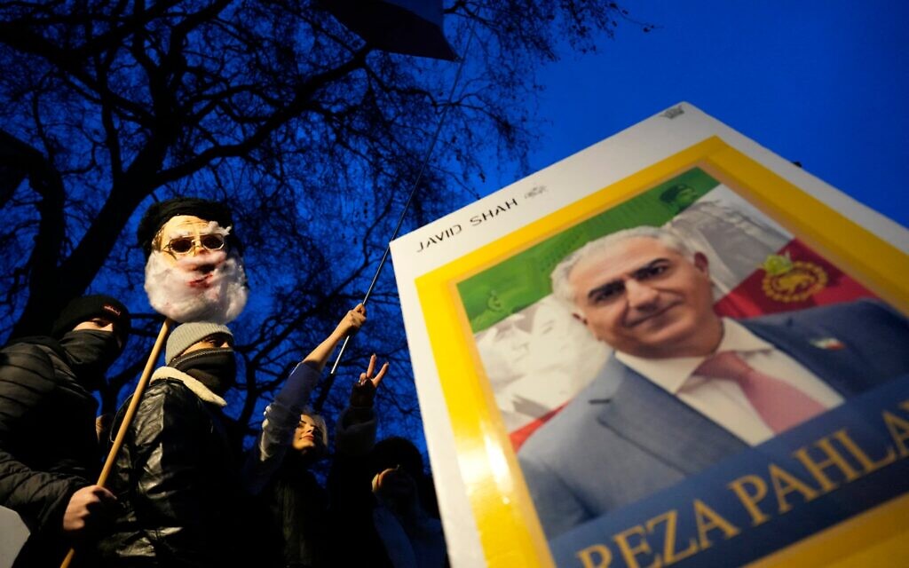 Un manifestant brandissant une pancarte à l'effigie de Reza Pahlavi, figure de l'opposition iranienne et fils du dernier shah d'Iran, lors d'un rassemblement en soutien aux manifestants anti-régime en Iran, dans le centre-ville de Londres, le 11 janvier 2026. (Crédit : Carlos Jasso/AFP)