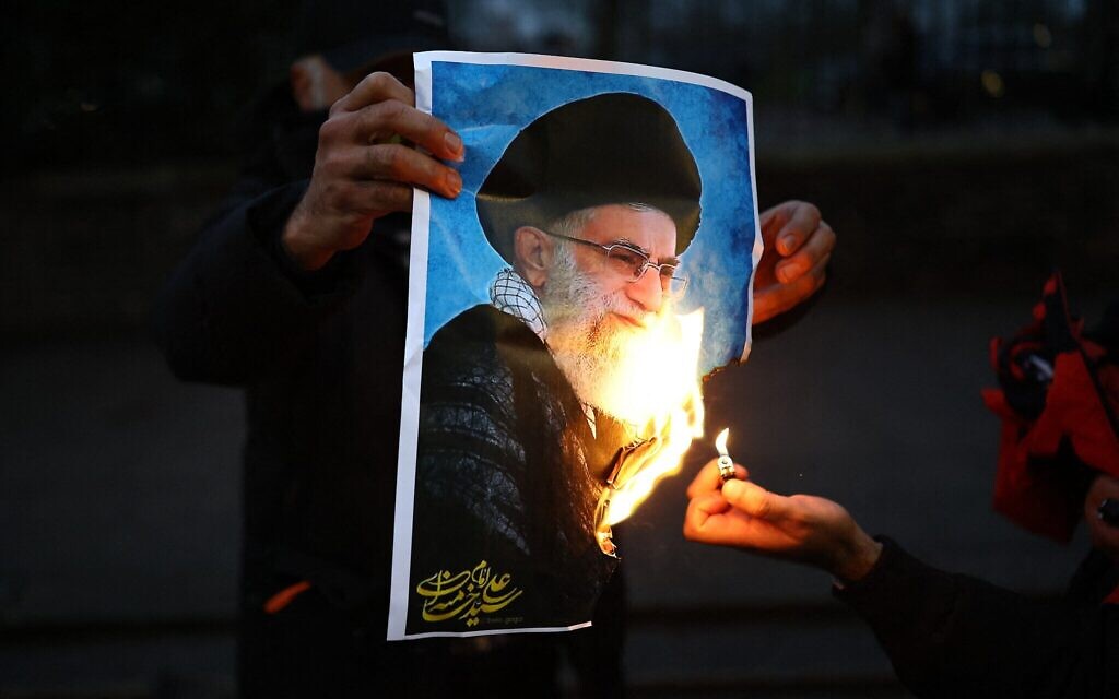 Des manifestants anti-régime iranien brûlant une image de l'ayatollah Ali Khamenei, lors d'un rassemblement devant l'ambassade d'Iran, dans le centre de Londres, le 12 janvier 2026. (Crédit : Henry Nicholls/AFP)