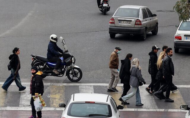 Illustration : des Iraniens traversent une rue dans la capitale Téhéran, le 15 janvier 2026. (Crédit : ATTA KENARE / AFP)