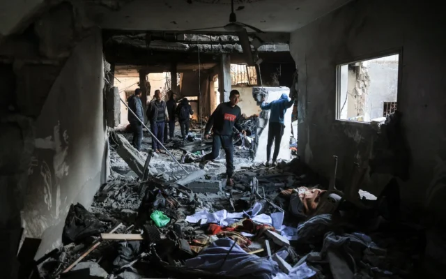 Des Palestiniens se frayent un chemin parmi les décombres et les meubles brisés, après une frappe israélienne présumée sur la maison familiale du commandant militaire du Hamas Muhammad al-Hawli, à l'ouest de Deir al-Balah, dans le centre de la bande de Gaza, le 16 janvier 2026. (Crédit : BASHAR TALEB / AFP) Des Palestiniens se frayent un chemin parmi les décombres et les meubles brisés, après une frappe israélienne présumée sur la maison familiale du commandant militaire du Hamas Muhammad al-Hawli, à l'ouest de Deir al-Balah, dans le centre de la bande de Gaza, le 16 janvier 2026. (Crédit : BASHAR TALEB / AFP)