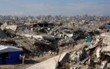 Des Gazaouis déplacés marchant parmi les décombres dans le camp de réfugiés de Jabaliya, dans le nord de la bande de Gaza, le 17 janvier 2026. (Crédit : Omar al-Qattaa/AFP)