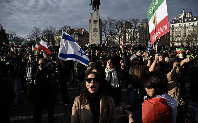 Des manifestants brandissant des drapeaux de l'État impérial iranien, communément appelé Iran Pahlavi, et des drapeaux d'Israël lors de la Marche pour l'Iran, un rassemblement de soutien au peuple iranien organisé par des royalistes et des partisans du fils du dernier shah d'Iran, Mohammad Reza Pahlavi, place Victor Hugo, à Paris, le 18 janvier 2026. (Crédit : Julien De Rosa/AFP)