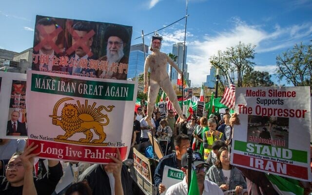 Des membres de la communauté iranienne et leurs sympathisants brandissant une poupée représentant le guide suprême iranien Ali Khamenei sur la potence, tandis que d'autres brandissent des pancartes et des drapeaux iraniens d'avant le régime lors d'un événement de « solidarité avec le peuple iranien » devant l'hôtel de ville, dans le centre-ville de Los Angeles, en Californie, le 18 janvier 2026. (Crédit : Apu Gomes/Getty Images North America/AFP)