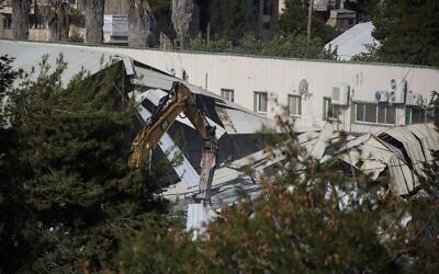 Des engins de chantier démolissant un bâtiment à l'intérieur du siège de l'Office très controversé de secours et de travaux de l'ONU pour les réfugiés de Palestine dans le Proche-Orient (UNRWA), dans le quartier de Sheikh Jarrah, à Jérusalem-Est, le 20 janvier 2026. (Crédit : Ilia Yefimovich/AFP)