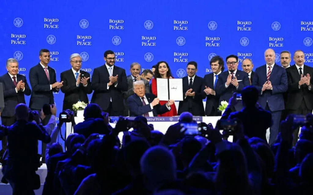 Le président du Paraguay Santiago Pena (deuxième à partir de la gauche), le Premier ministre pakistanais Shehbaz Sharif (cinquième à partir de la gauche), la présidente du Kosovo Vjosa Osmani (au centre à droite), le président argentin Javier Milei (sixième à partir de la droite), le Premier ministre arménien Nikol Pashinyan (quatrième à partir de la droite), l'ancien Premier ministre bulgare Rosen Zhelyazkov (troisième à droite), le ministre turc des Affaires étrangères Hakan Fidan (deuxième à droite) et le président azerbaïdjanais Ilham Aliyev posent avec le président américain Donald Trump (au centre) tenant une charte fondatrice signée lors de la réunion du "Conseil de la paix" pendant la réunion annuelle du Forum économique mondial (WEF) à Davos, le 22 janvier 2026. (Crédit: Fabrice Coffrini / AFP)