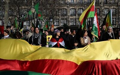 Des manifestants brandissent un immense drapeau kurde du Rojava syrien lors d'une manifestation de solidarité avec les Kurdes du nord de la Syrie, place de la République, à Paris, le 24 janvier 2026. (Crédit : Blanca Cruz / AFP) Des manifestants brandissent un immense drapeau kurde du Rojava syrien lors d'une manifestation de solidarité avec les Kurdes du nord de la Syrie, place de la République, à Paris, le 24 janvier 2026. (Crédit : Blanca Cruz / AFP)
