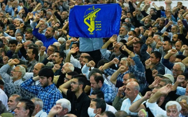 Un Iranien brandissant une banderole arborant l’emblème des Gardiens de la révolution tandis que les autres scandent des slogans lors de la cérémonie de prière du vendredi sur le campus de l’université de Téhéran, en Iran, le 13 juin 2025. (Crédit : Vahid Salemi/AP) Un Iranien brandissant une banderole arborant l’emblème des Gardiens de la révolution tandis que les autres scandent des slogans lors de la cérémonie de prière du vendredi sur le campus de l’université de Téhéran, en Iran, le 13 juin 2025. (Crédit : Vahid Salemi/AP)