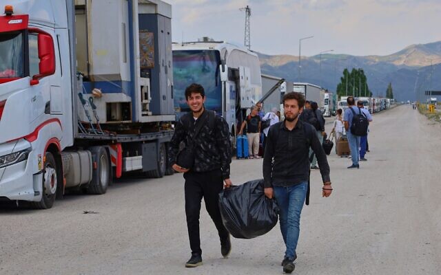 Des Iraniens arrivant pour passer en Turquie au poste-frontière de Gurbulak Bazargan, à la frontière irano-turque, le 16 juin 2025. (Crédit : Kadir Cesur/AP)