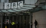 Une personne passe devant le siège de la BBC à Londres, le 10 novembre 2025. (Crédit : Kin Cheung/AP)