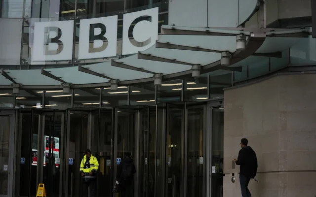Une personne passe devant le siège de la BBC à Londres, le 10 novembre 2025. (Crédit : Kin Cheung/AP)
