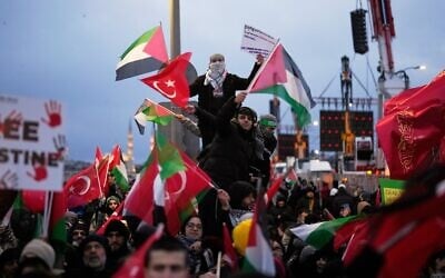 Des manifestants rassemblés sur le pont de Galata, brandissant des drapeaux "palestiniens" et turcs, lors d'un rassemblement anti-Israël à Istanbul, en Turquie, le 1ᵉʳ janvier 2026. (Crédit : Khalil Hamra/AP)