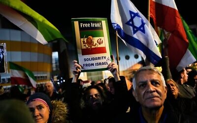 Des manifestants brandissent le drapeau israélien et le drapeau iranien d'avant la révolution lors d'un rassemblement en soutien aux manifestations antigouvernementales en Iran, à Holon, en Israël, le 14 janvier 2026. (Crédit : AP Photo/Ohad Zwigenberg)