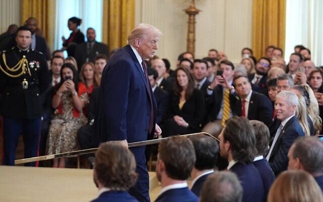 Le président américain Donald Trump porte un bâton de hockey alors qu'il quitte un événement organisé en l'honneur des Florida Panthers, champions de la Stanley Cup 2025, dans la salle Est de la Maison Blanche, le 15 janvier 2026, à Washington. (Crédit : AP/Evan Vucci)