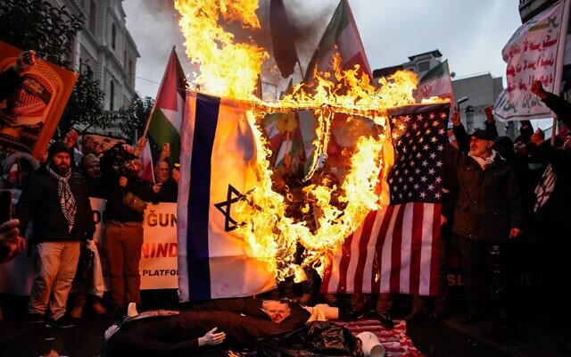 Des personnes brûlent des drapeaux américains et israéliens lors d'un rassemblement en soutien au gouvernement iranien, à Istanbul, en Turquie, le dimanche 18 janvier 2026. (Crédit : AP/Emrah Gurel)