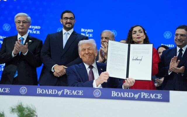 Le président américain Donald Trump (au centre) exhibant la Charte signée du « Conseil de Paix » lors de la réunion annuelle du Forum économique mondial, à Davos, en Suisse, le 22 janvier 2026. (Crédit : Evan Vucci/AP)