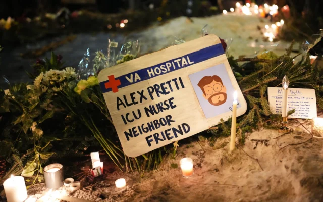 Une pancarte à la mémoire d'Alex Pretti, 37 ans, tué par balle plus tôt dans la journée par un agent de la police des frontières américaine, est déployée lors d'une veillée organisée le 24 janvier 2026 à Minneapolis, dans le Minnesota. (Crédit : AP/Adam Gray)