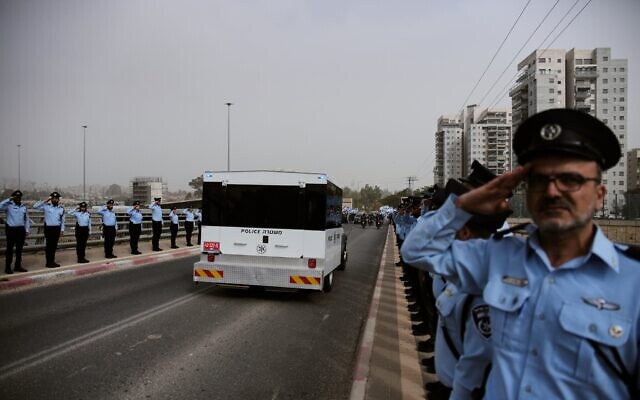 Des policiers saluant alors que le convoi transportant le cercueil de Ran Gvili, dernier otage dont le corps a été retrouvé dans la bande de Gaza, traversant Matzliah, dans le centre d'Israël, en route vers ses funérailles, le 28 janvier 2026. (Crédit : Ohad Zwigenberg/AP Photo)