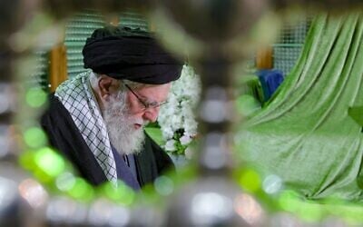 Sur cette photo publiée par le site officiel du bureau du guide suprême iranien, le guide suprême, l'ayatollah Ali Khamenei, prie sur la tombe du défunt fondateur de la république islamique, l'ayatollah Khomeini, commémorant le 47e anniversaire de son retour d'exil pendant la révolution islamique de 1979, juste à l'extérieur de Téhéran, en Iran, le 31 janvier 2026. (Crédit : Bureau du guide suprême iranien via AP)