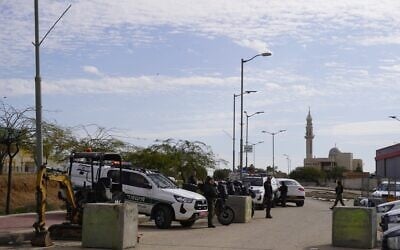 Des forces de la garde nationale et d'autres agents de police des frontières se tenant à l'entrée du village bédouin de Tarabin al-Sana, qui a été fermé à l'aide de parpaings, le 31 décembre 2025. (Crédit : Charlie Summers/Times of Israel)