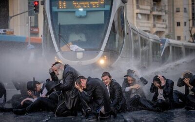 La police utilisant un canon à eau pour disperser des ultra-orthodoxes lors d'une manifestation contre la conscription militaire, à Jérusalem, le 23 mai 2024. (Crédit : Chaïm Goldberg/Flash90)