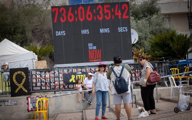 Des visiteurs se tenant devant le compteur affichant le nombre de jours écoulés depuis la capture de 251 otages le 7 octobre 2023, sur la Place des Otages, à Tel Aviv, le 12 octobre 2025. (Crédit : Miriam Alster/FLASH90)