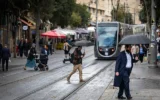 Des passants marchent sous la pluie dans la rue Jaffa, dans le centre de Jérusalem, le 25 novembre 2025. (Yonatan Sindel/Flash90)