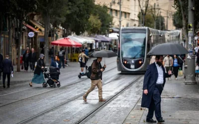 Des passants marchent sous la pluie dans la rue Jaffa, dans le centre de Jérusalem, le 25 novembre 2025. (Yonatan Sindel/Flash90)