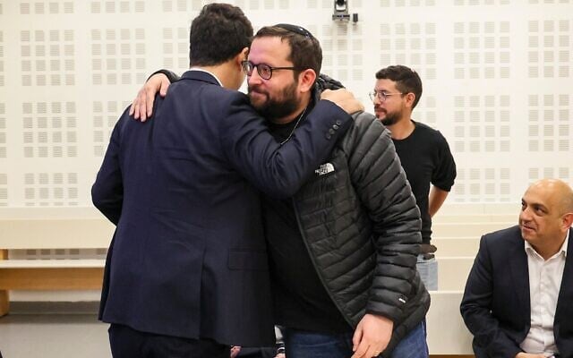 Jonatan Urich (à droite) saluant l'avocat Amit Hadad (à gauche) lors d'une audience dans le cadre de l'enquête Qatargate, au tribunal de Lod, le 6 janvier 2026. (Crédit : Jonathan Shaul/Flash90) Jonatan Urich (à droite) saluant l'avocat Amit Hadad (à gauche) lors d'une audience dans le cadre de l'enquête Qatargate, au tribunal de Lod, le 6 janvier 2026. (Crédit : Jonathan Shaul/Flash90)