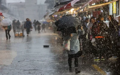 Des gens marchent sous la pluie au marché Mahane Yehuda à Jérusalem, le 9 janvier 2026 (Crédit : Chaim Goldberg/Flash90)