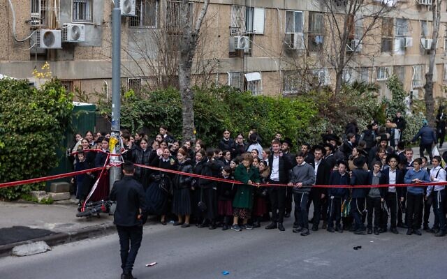 Des passants sur les lieux d'un incident vraisemblablement lié à des substances toxiques dans une crèche non agréée, à Jérusalem, le 19 janvier 2026. (Crédit :  Chaïm Goldberg/Flash90)