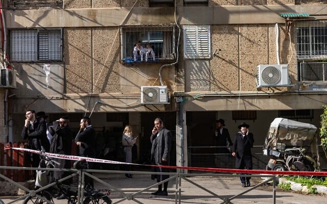 Des passants sur les lieux d'un accident où de nombreux enfants en bas âge ont été retrouvés en détresse respiratoire, dans une crèche illégale du quartier majoritairement ultra-orthodoxe de Romema, à Jérusalem, le 19 janvier 2026. (Crédit :  Chaïm Goldberg/Flash90)