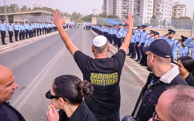 Itzik Gvili, le père du sergent-chef Ran Gvili, policier enlevé et assassiné le 7 octobre 2023, remerciant les agents de police israéliens postés le long du parcours du cortège funèbre, le 28 janvier 2026. (Crédit : Avshalom Sassoni/Flash90)