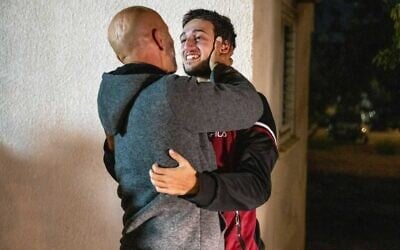 Liam Or-Nassar, otage libéré de Gaza, dans les bras de son père Ramzi Nassar à la base aérienne de Hatzerim, tôt le matin du 30 novembre 2023. (Crédit : Unité du porte-parole de l'armée israélienne) Liam Or-Nassar, otage libéré de Gaza, dans les bras de son père Ramzi Nassar à la base aérienne de Hatzerim, tôt le matin du 30 novembre 2023. (Crédit : Unité du porte-parole de l'armée israélienne)