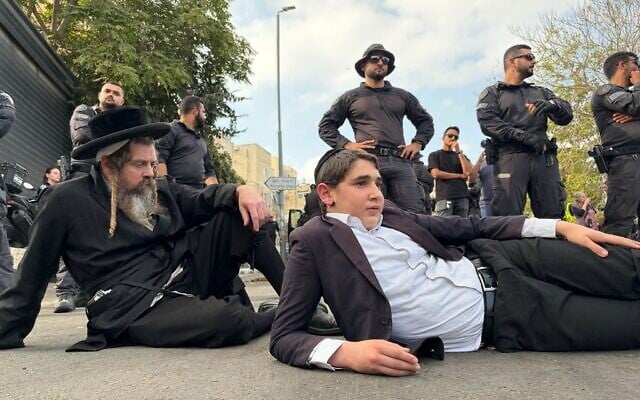 Des hommes haredim bloquent la route devant le centre de recrutement de l'armée israélienne à Jérusalem, le 12 novembre 2025. (Crédit : Sam Sokol/Times of Israel) Des hommes haredim bloquent la route devant le centre de recrutement de l'armée israélienne à Jérusalem, le 12 novembre 2025. (Crédit : Sam Sokol/Times of Israel)