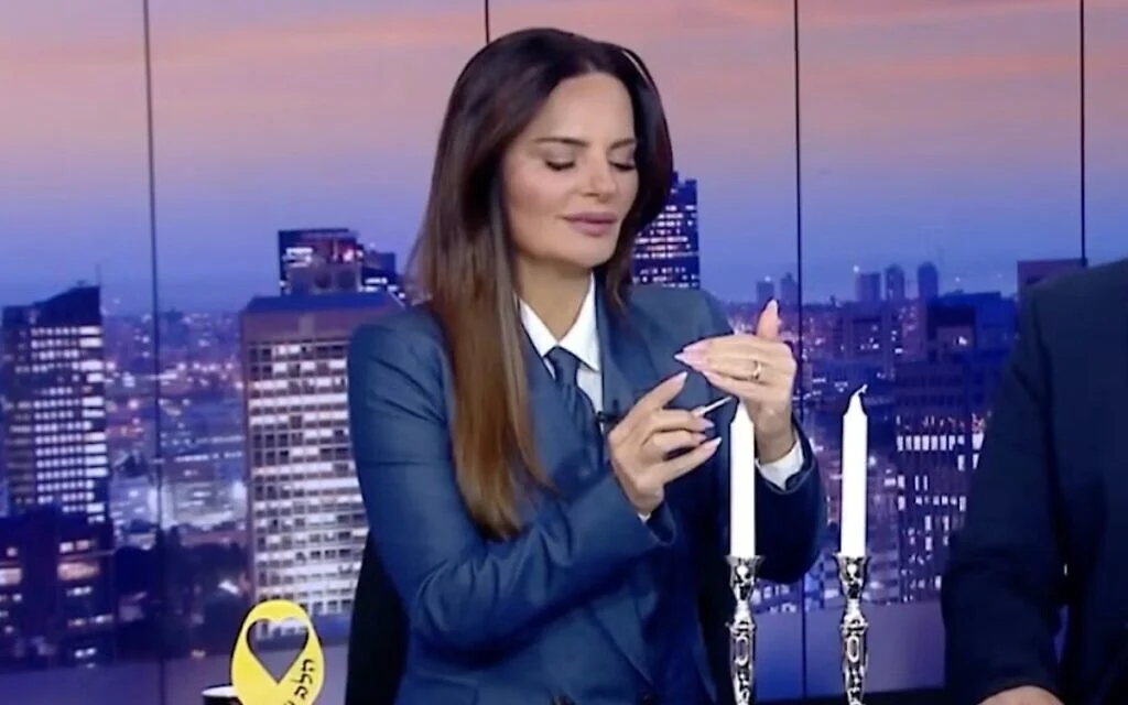 L'animatrice israélienne Ofira Asayag est laïque mais a allumé des bougies du Shabbat à l'antenne en 2024, pendant la guerre Israël-Hamas - signe d'une nouvelle tendance des Israéliens. (Crédit : Capture d'écran via la JTA) L'animatrice israélienne Ofira Asayag est laïque mais a allumé des bougies du Shabbat à l'antenne en 2024, pendant la guerre Israël-Hamas - signe d'une nouvelle tendance des Israéliens. (Crédit : Capture d'écran via la JTA)