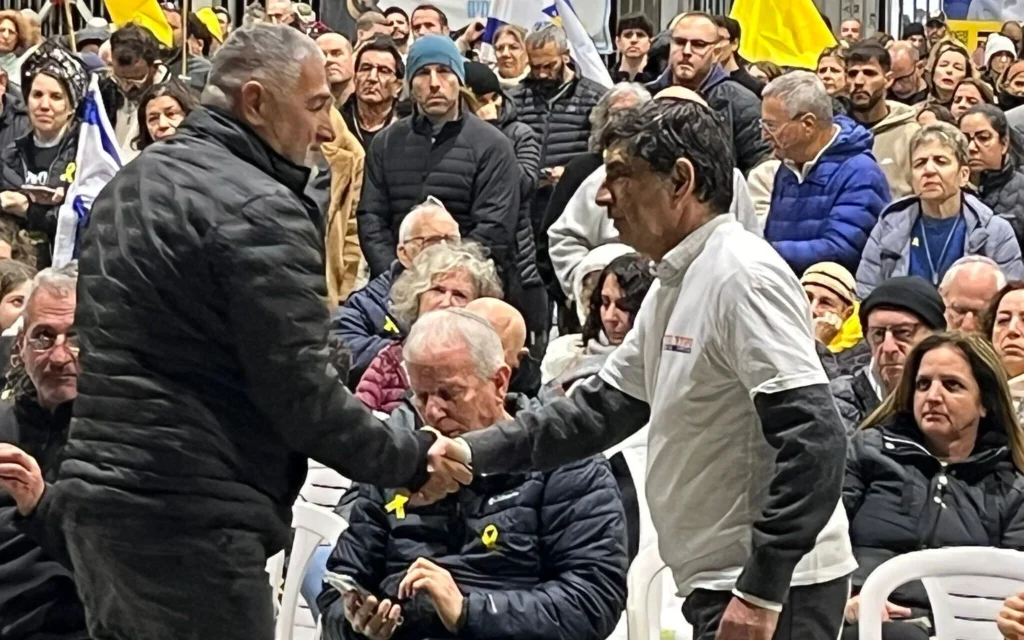 Itzik Gvili, père de Ran Gvili, otage tué lors du 7-Octobre, serre la main de Simcha Goldin le 3 janvier 2026 à Meitar. (Crédit : Forum des otages)
