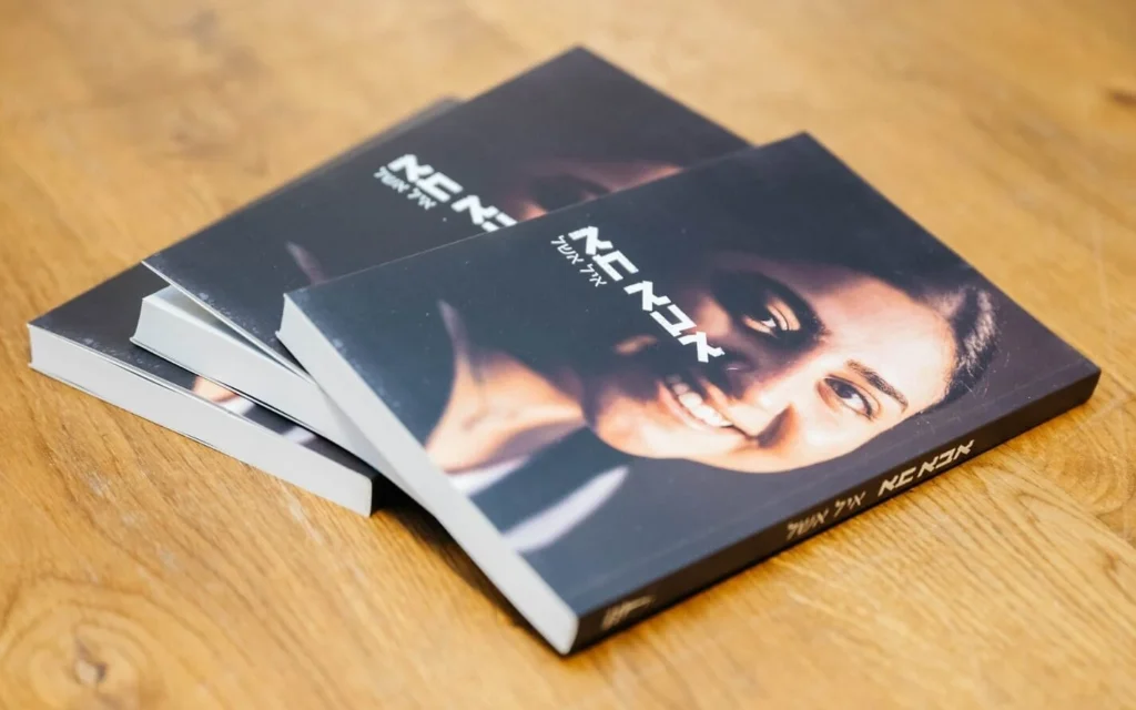 La couverture de « Abba Ba » (Papa arrive), le livre écrit par Eyal Eshel, père endeuillé, sur sa fille Roni Eshel, soldat de surveillance tuée le 7 octobre 2023, lors du lancement du livre le 9 janvier 2026 au musée Anu. (Crédit : Nadav Margalit/Sella Meir Publishing) La couverture de « Abba Ba » (Papa arrive), le livre écrit par Eyal Eshel, père endeuillé, sur sa fille Roni Eshel, soldat de surveillance tuée le 7 octobre 2023, lors du lancement du livre le 9 janvier 2026 au musée Anu. (Crédit : Nadav Margalit/Sella Meir Publishing)
