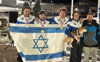 L'équipe israélienne de bobsleigh, menée par AJ Edelman (deuxième à partir de la droite), pose avec le drapeau israélien après une course à Lake Placid, dans l'État de New York. (Autorisation : Comité olympique israélien)
