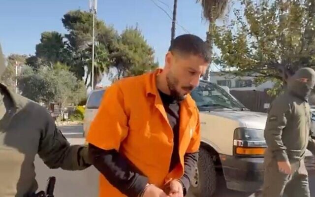 Nidal Abu Latif (au centre), entouré d'officiers dans une vidéo diffusée par la police israélienne le 5 janvier 2025 (Crédit : Capture d'écran)