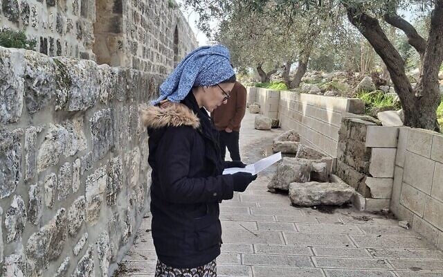 Une femme récite des prières à partir d'un dépliant distribué par la yeshiva du mont du Temple sur le mont du Temple, dans la Vieille ville de Jérusalem, le 21 janvier 2026. (Autorisation : Beyadenu)